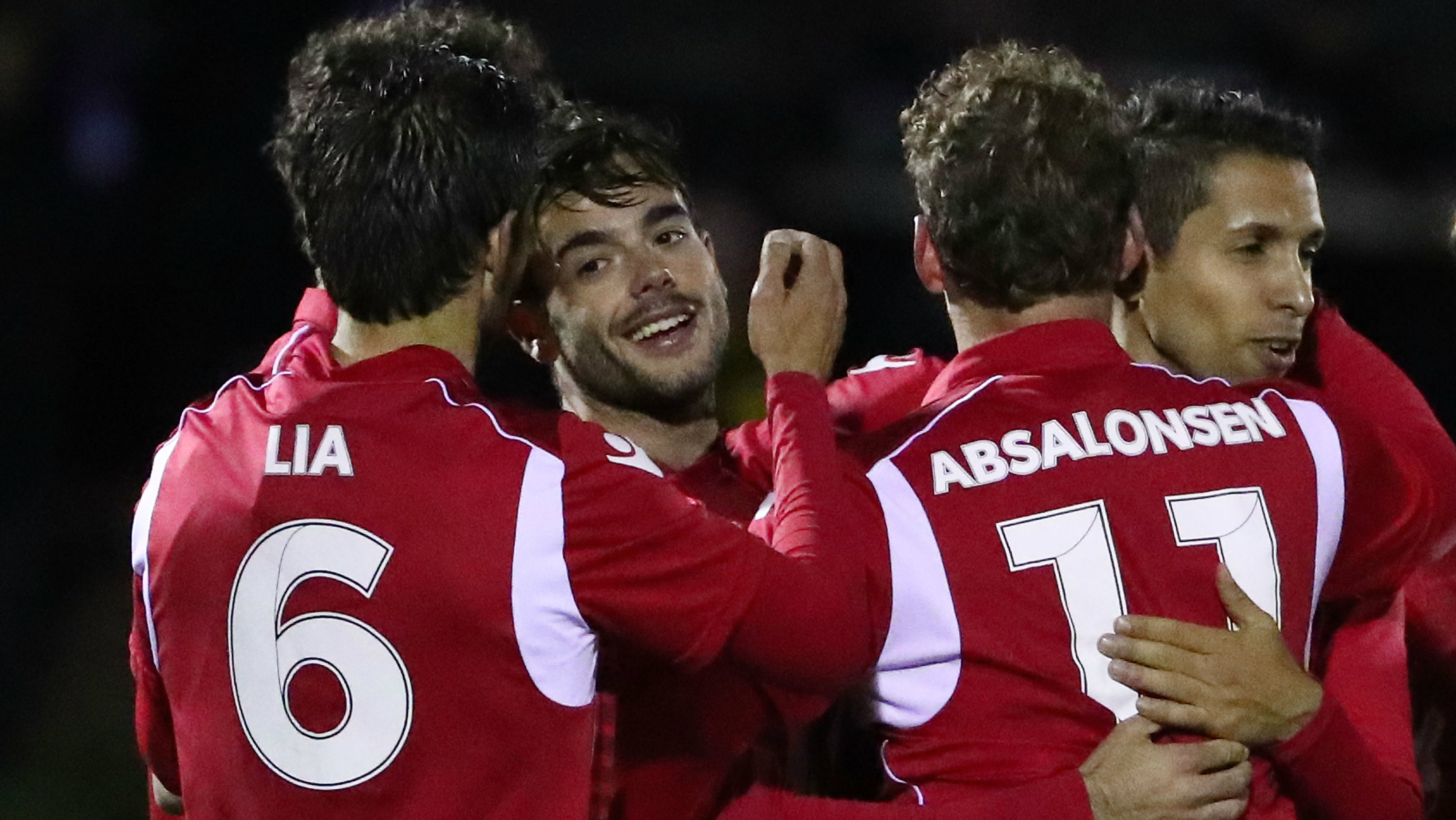 Adelaide United players celebrate one of Nikola Mileusnic's three goals against Heidelberg United.