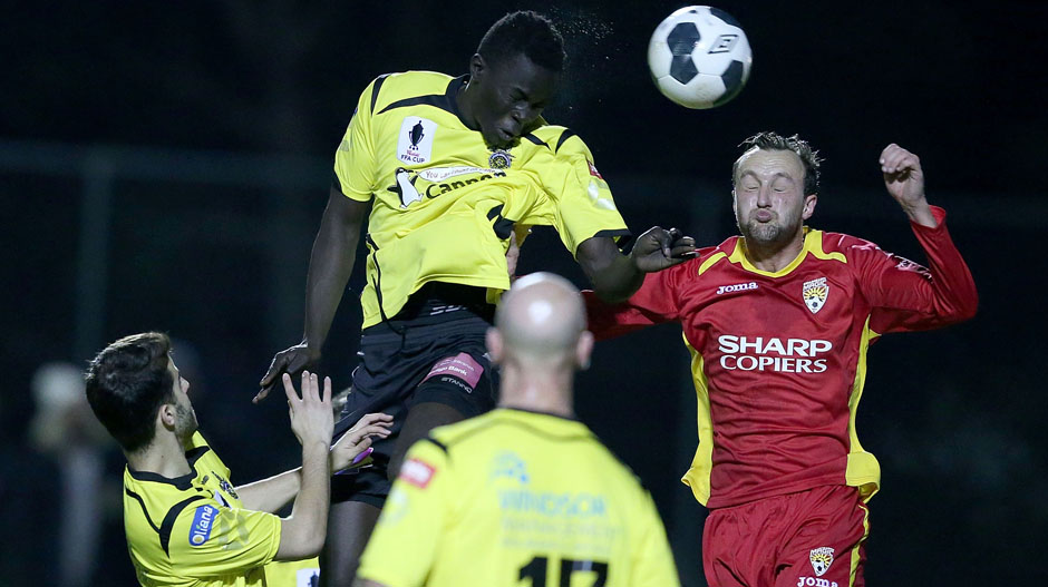 Ken Athiu of Heidelberg contests a header with Benjamin Higgins of Broadmeadow Magic.