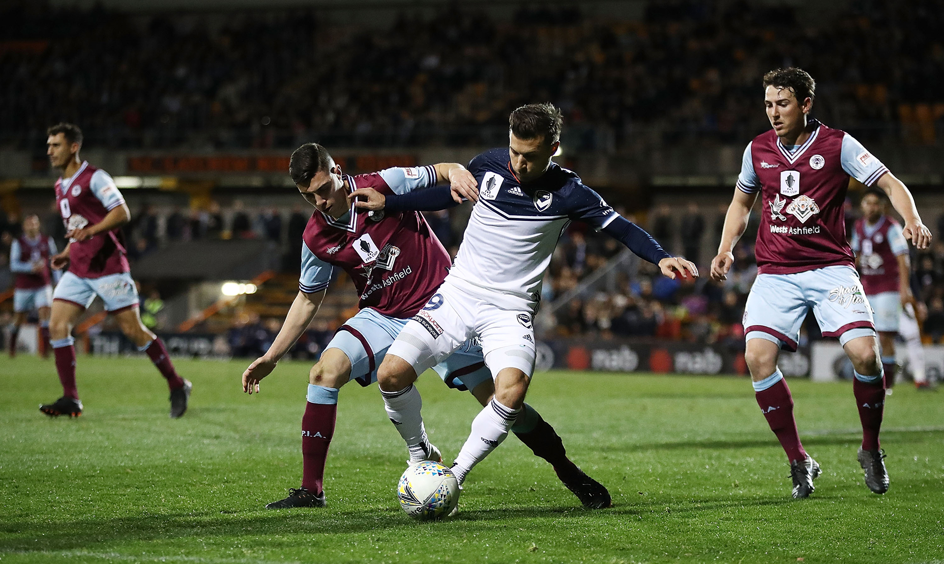 Kosta Barbarouses of the victory is challenged by Paul Galami of APIA Leichhardt Tigers during the Australia Cup round of 16 match between APIA Leichhardt Tigers FC and Melbourne Victory at Leichhardt Oval on August 21, 2018