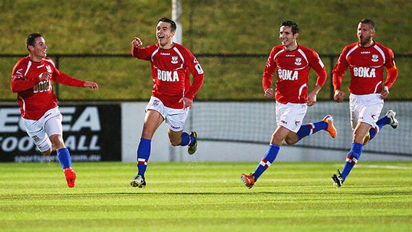 Anthony Tomelic of Sydney United 58 FC celebrates scoring at home with teammates.