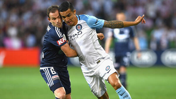 Tim Cahill fights for the ball with Victory midfielder Leigh Broxham.