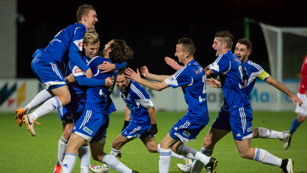 South Melbourne players celebrate scoring against the Melbourne Knights.
