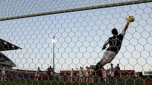Perth Glory goalkeeper Danny Vukovic flies high against the Jets.
