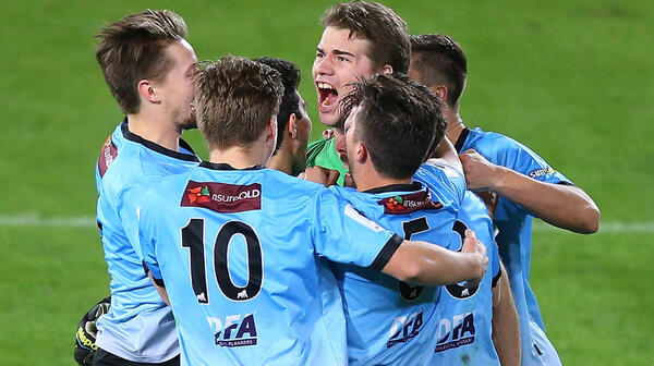 Palm Beach goalkeeper Shane Viitakangas is mobbed by teammates after saving decisive penalty against South Melbourne.