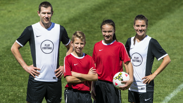 Play Football ambassadors Brett Emerton and Steph Catley with two young football stars.