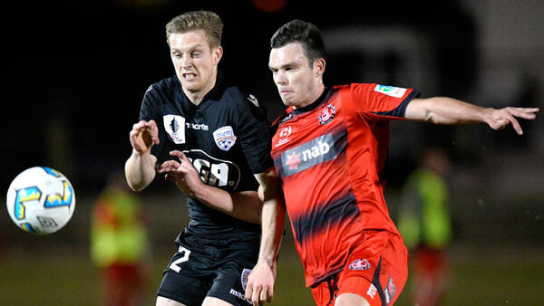 Adelaide's Ryan Kitto battles for the ball with Redlands defender Grant Brix.