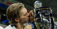 Luke Brattan kisses the Australia Cup after winning the trophy for a third time